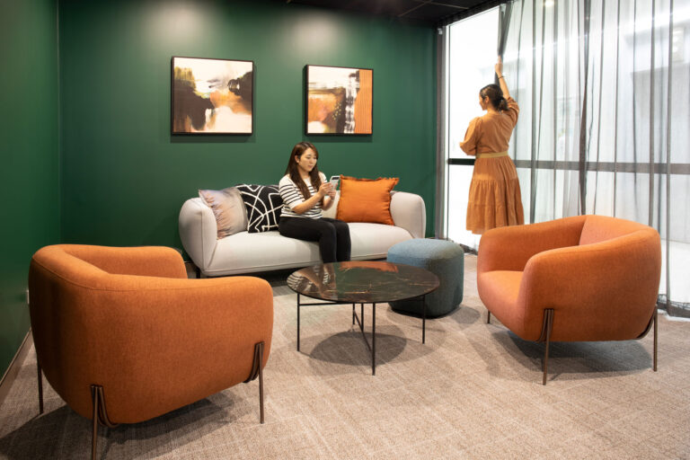 two women in a meeting room with lounge chairs