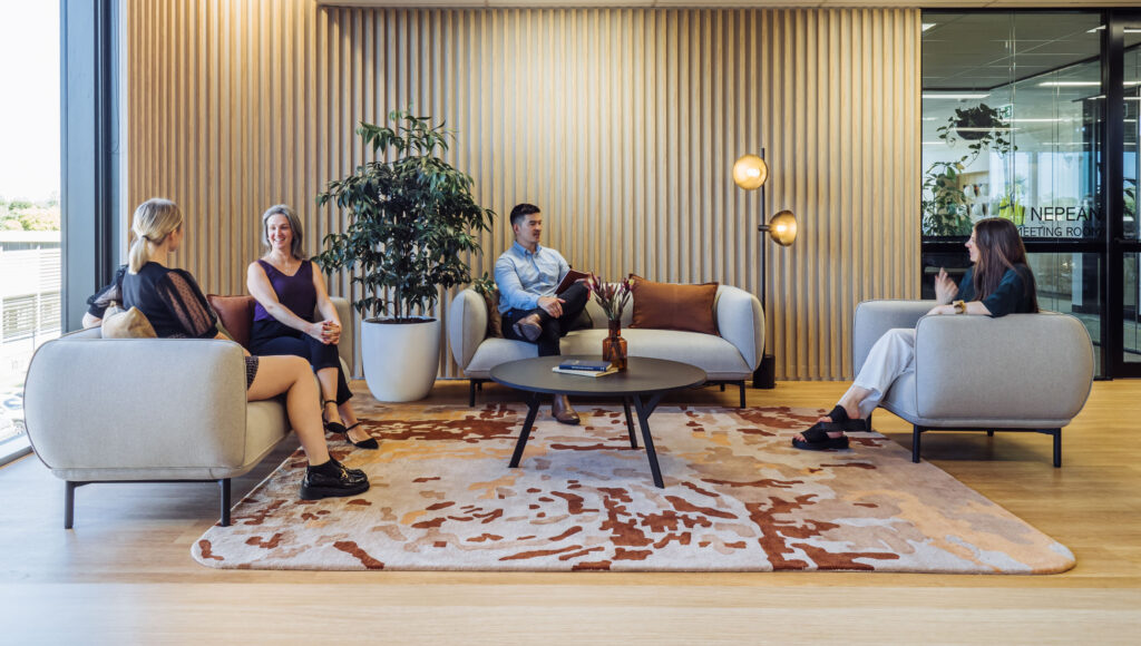 a group of people sitting on lounge chairs in an office