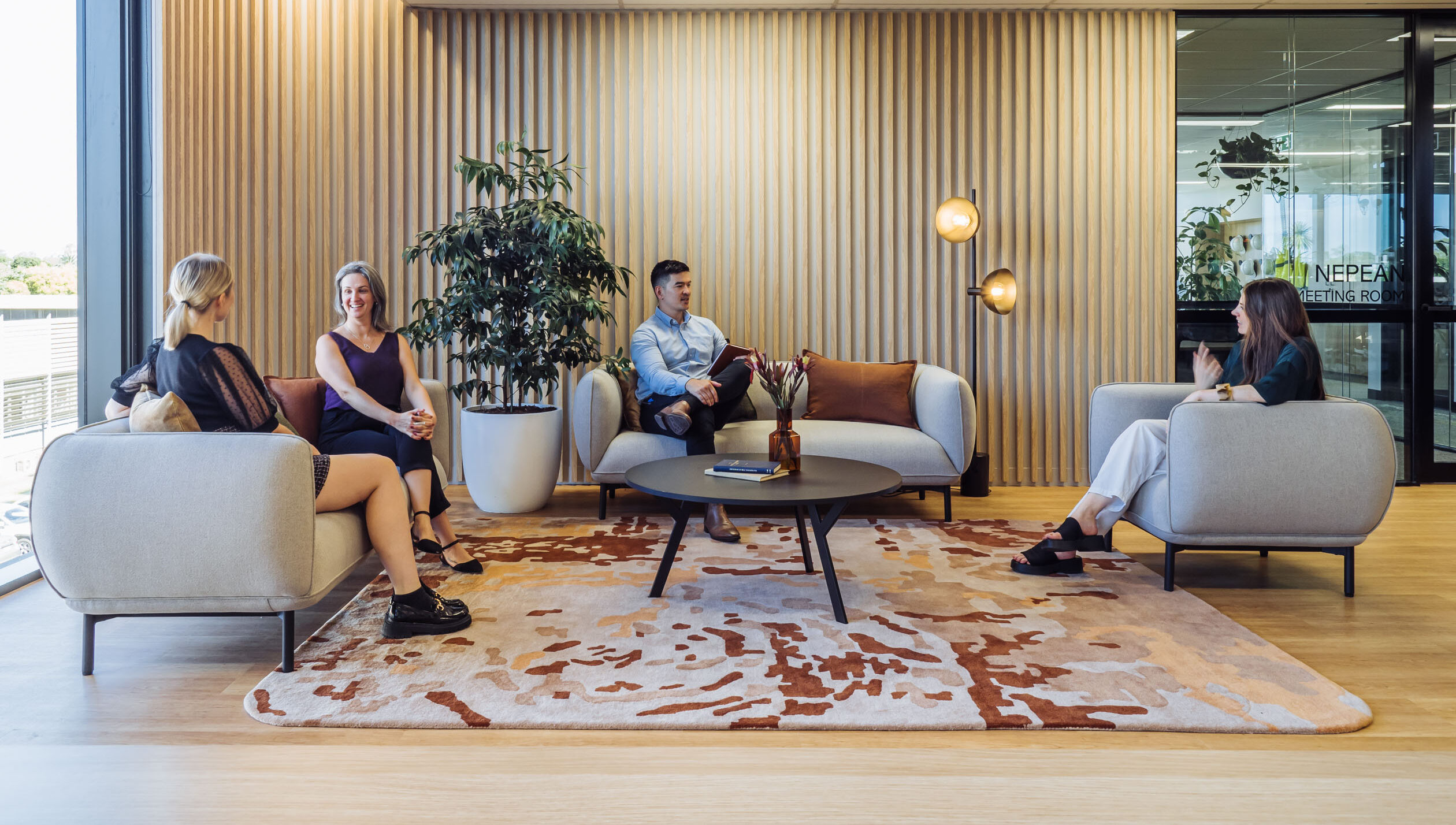 a group of people sitting on lounge chairs in an office