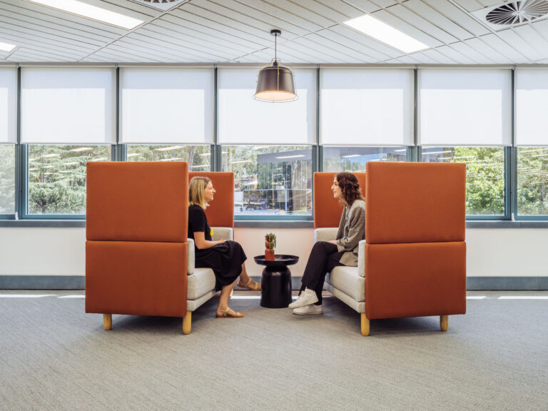 two women talking in a module chairs in an office