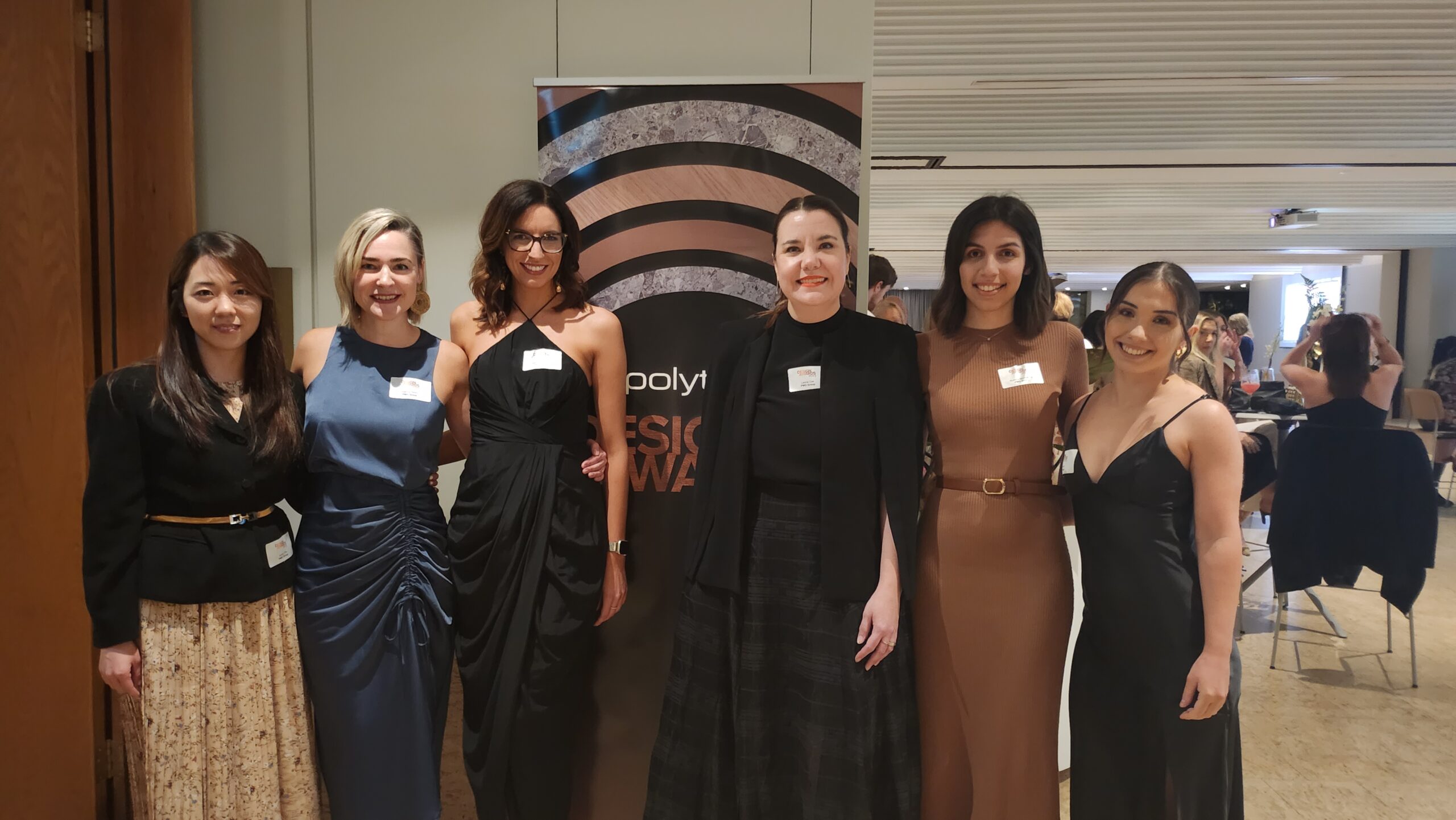 group of women standing in front of the polytec design awards sign