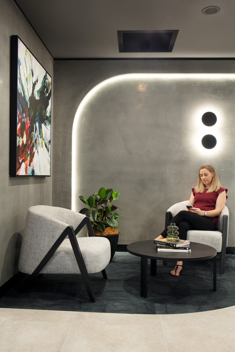 woman sits in reception area of an office