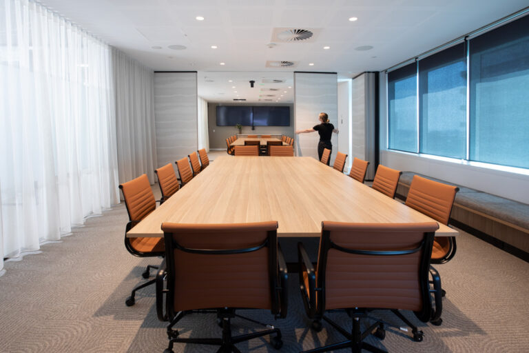 woman moves an operable wall in a meeting room