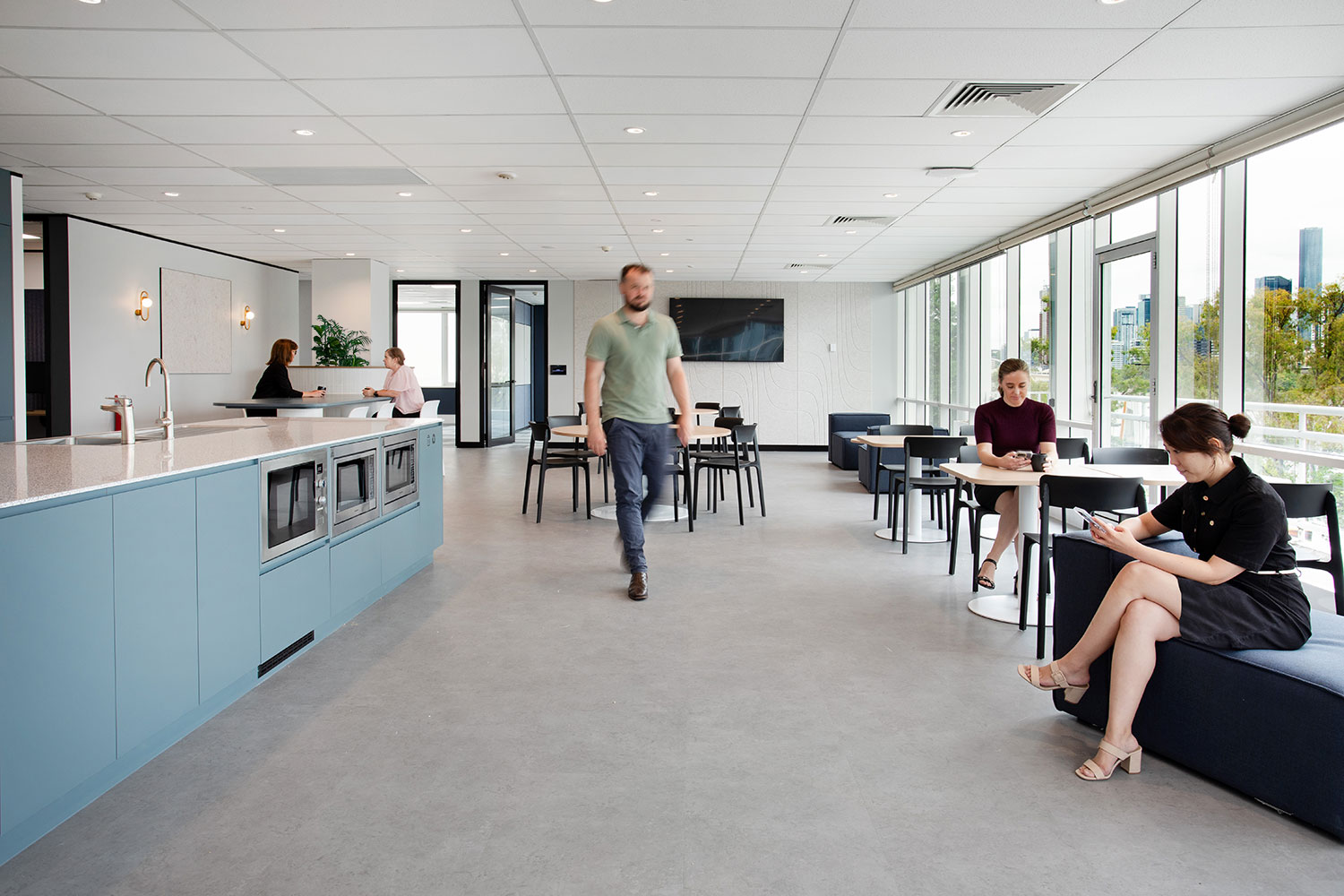 man walking through kitchen in an office space